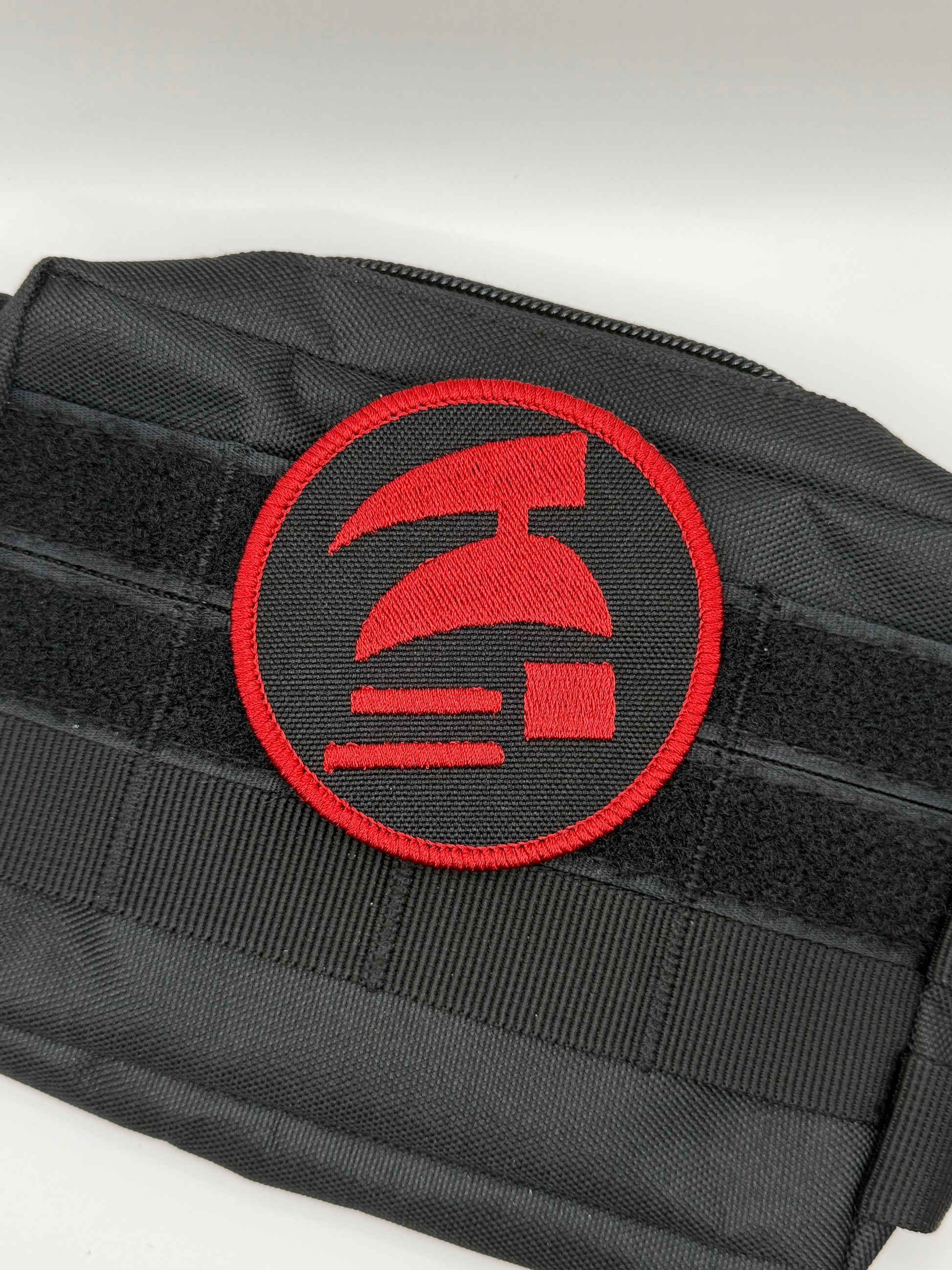 Black pouch with a red emblem on a white background. Hardcore ironman logo