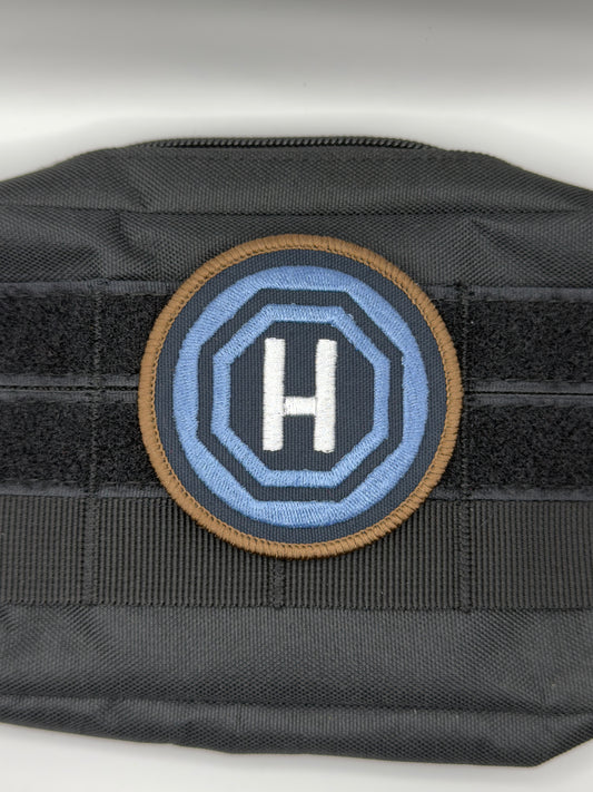 Circular home teleport patch with letter 'H' in the center on a white background