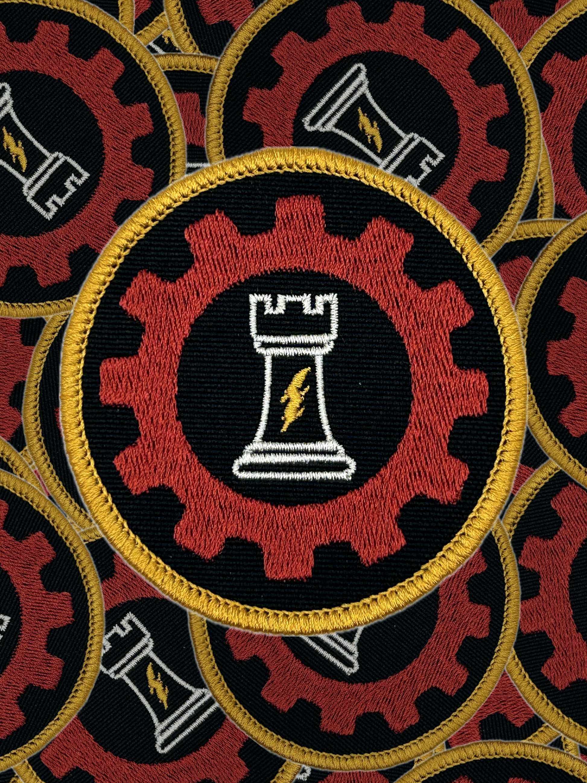 Patch with a chess piece and gear design on a black background, surrounded by similar patches.