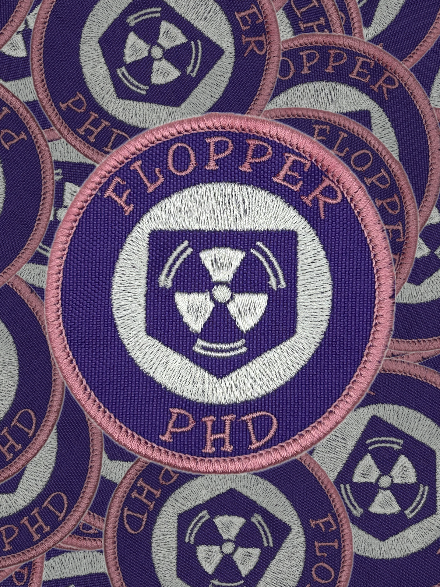 Collection of 'FLOPPER' patches with a radiation symbol on a blue background