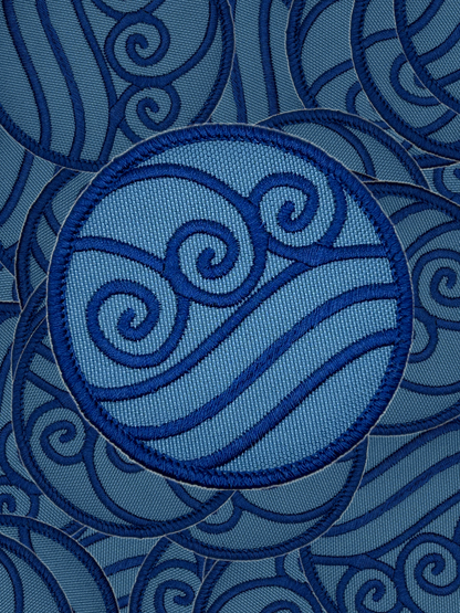 Blue embroidered water bending design on a blue fabric background