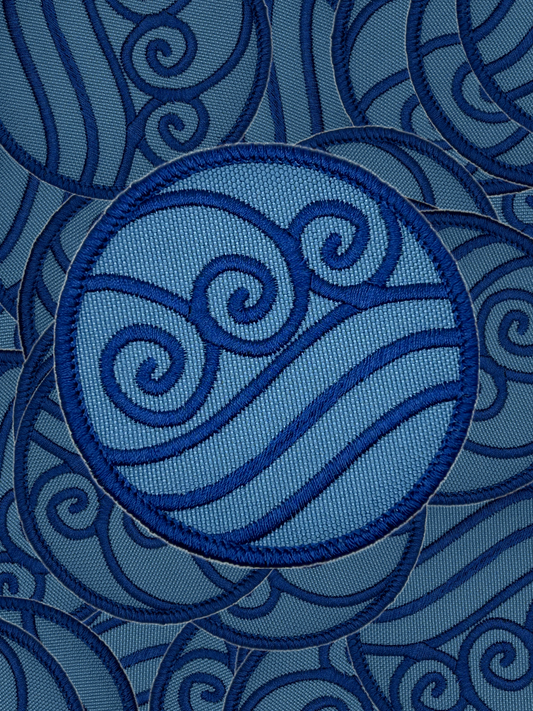Blue embroidered water bending design on a blue fabric background