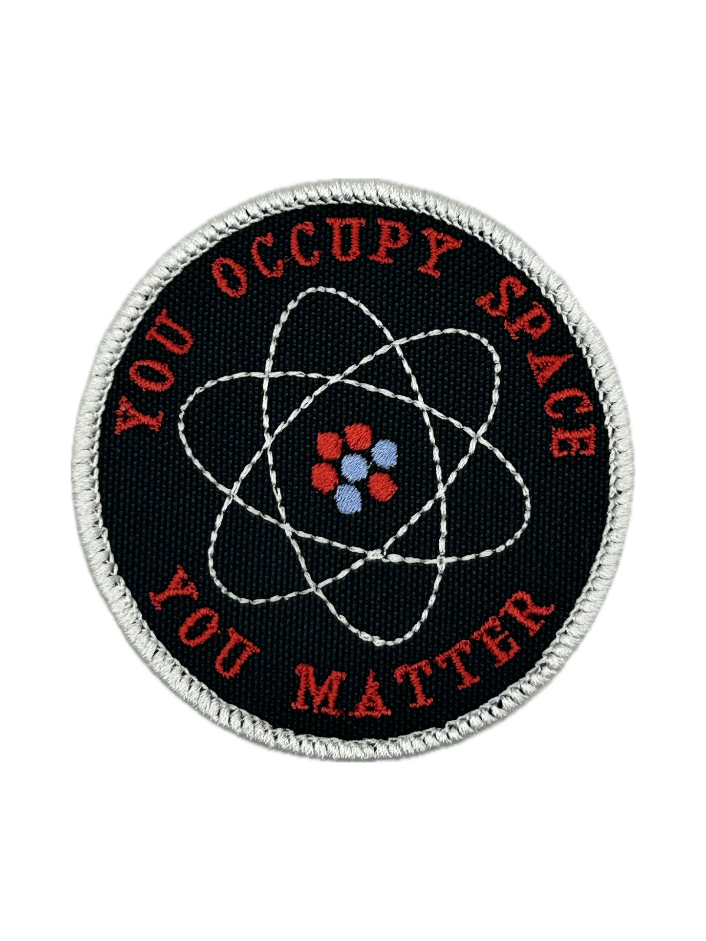Round patch with atomic symbol and text 'YOU OCCUPY SPACE YOU MATTER' on a black background