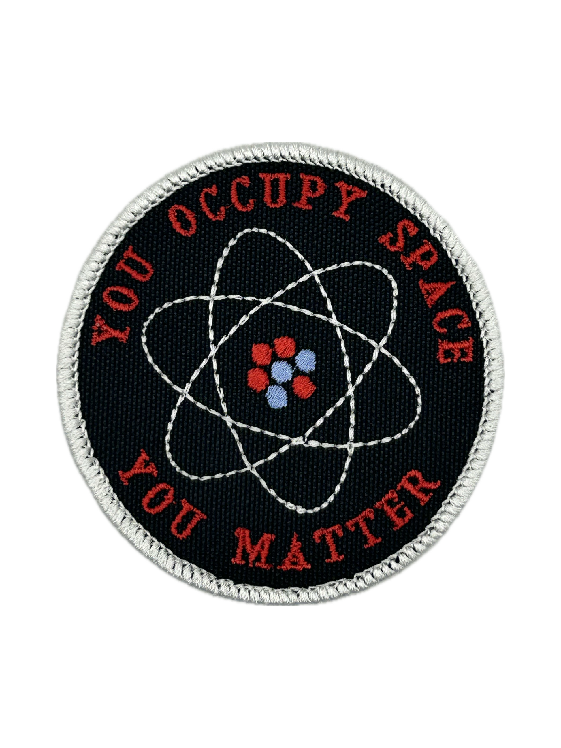 Round patch with atomic symbol and text 'YOU OCCUPY SPACE YOU MATTER' on a black background