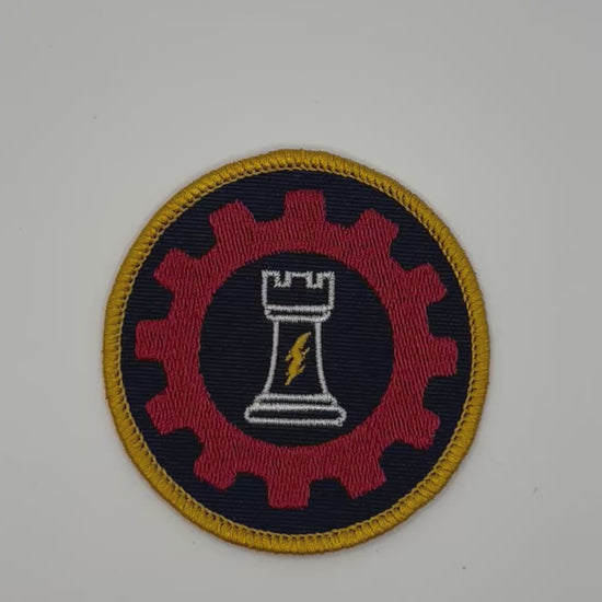 Circular patch with a red gear, white chess piece, and yellow border for ordo reductor on a black background