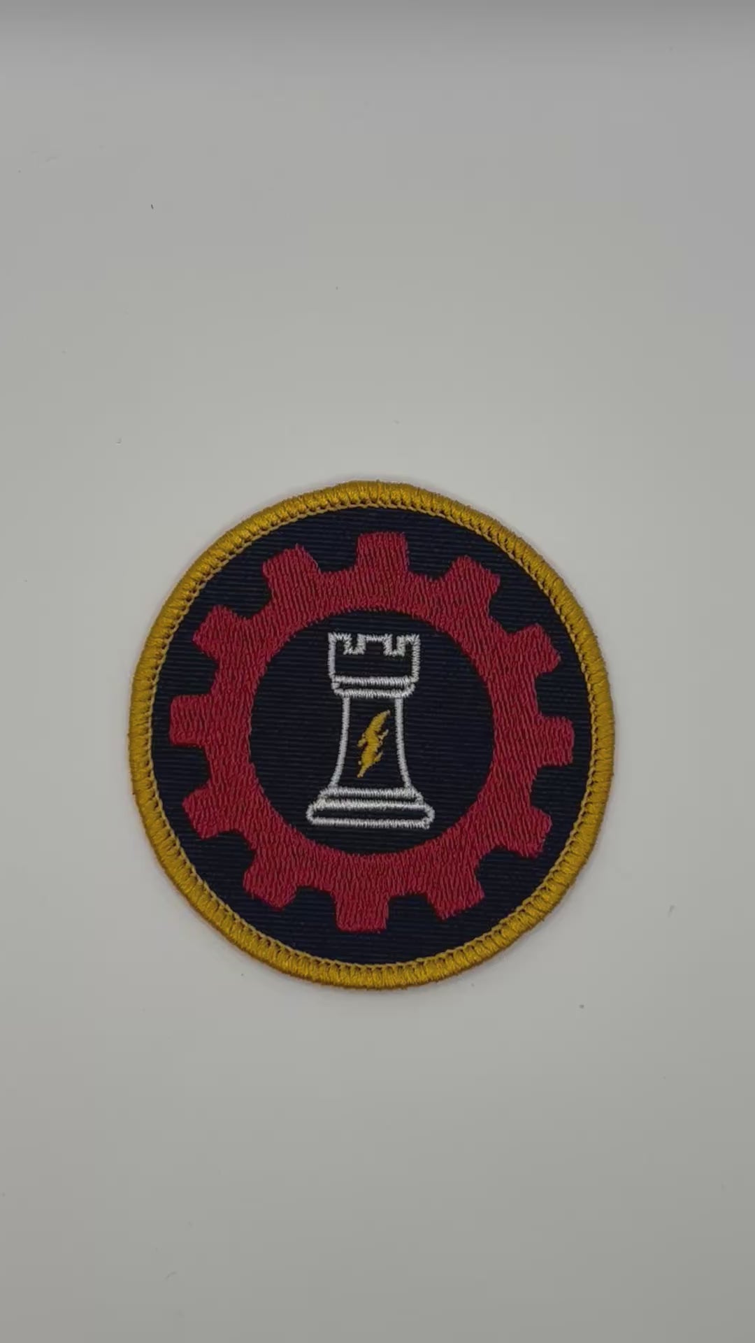 Circular patch with a red gear, white chess piece, and yellow border for ordo reductor on a black background