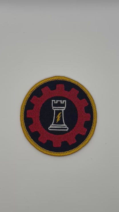 Circular patch with a red gear, white chess piece, and yellow border for ordo reductor on a black background