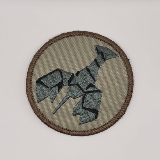 Circular patch with a stylized burnt lobster design on a beige background