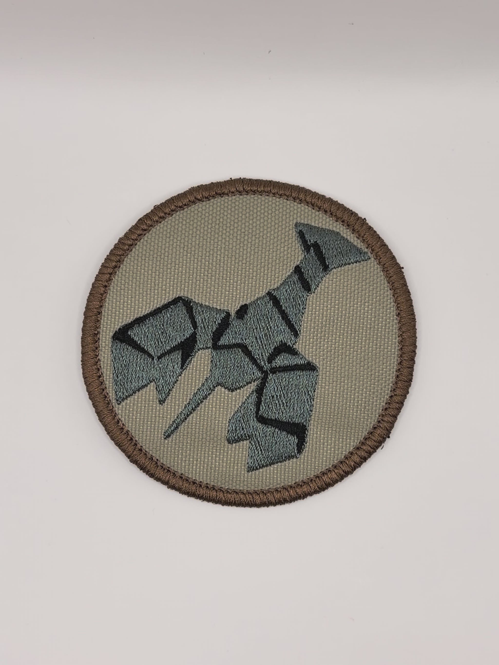 Circular patch with a stylized burnt lobster design on a beige background