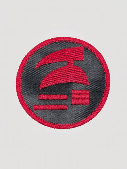 Red and black circular patch with a logo on a white background. Hardcore ironman logo patch.