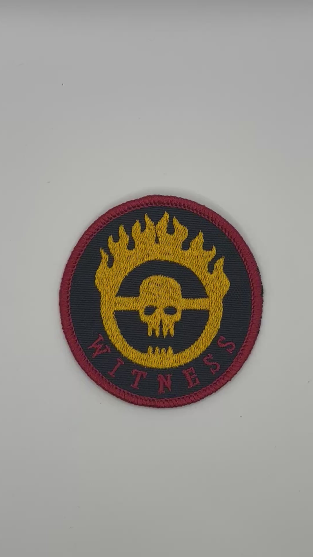 Round patch with skull design and 'Witness' text on a black background